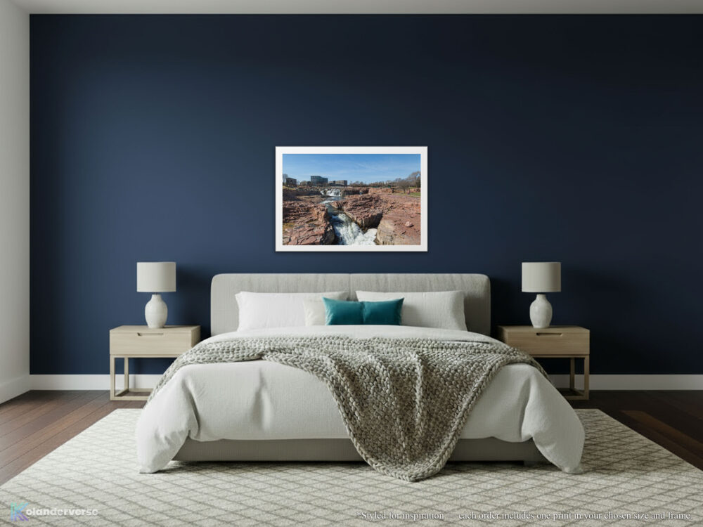 Big Sioux River waterfalls white framed print hanging on navy colored wall in modern bedroom.