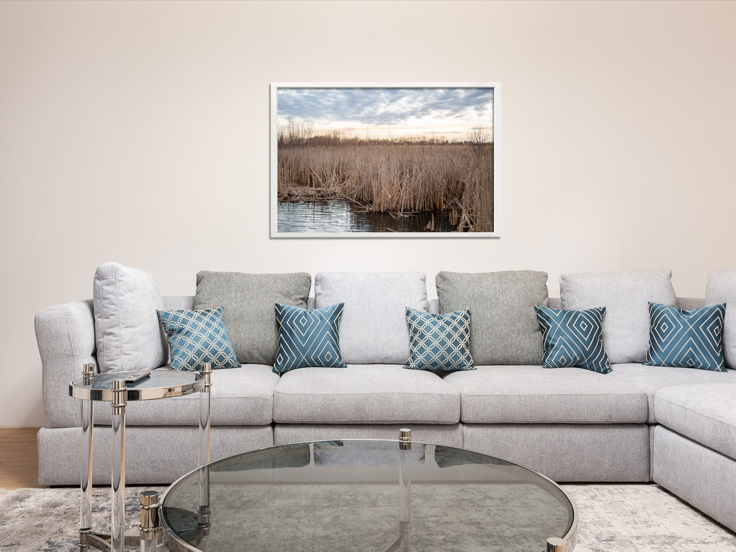 Cattails in Winter Wetlands Marsh in a white frame hanging on the living room wall above a modern sofa couch.